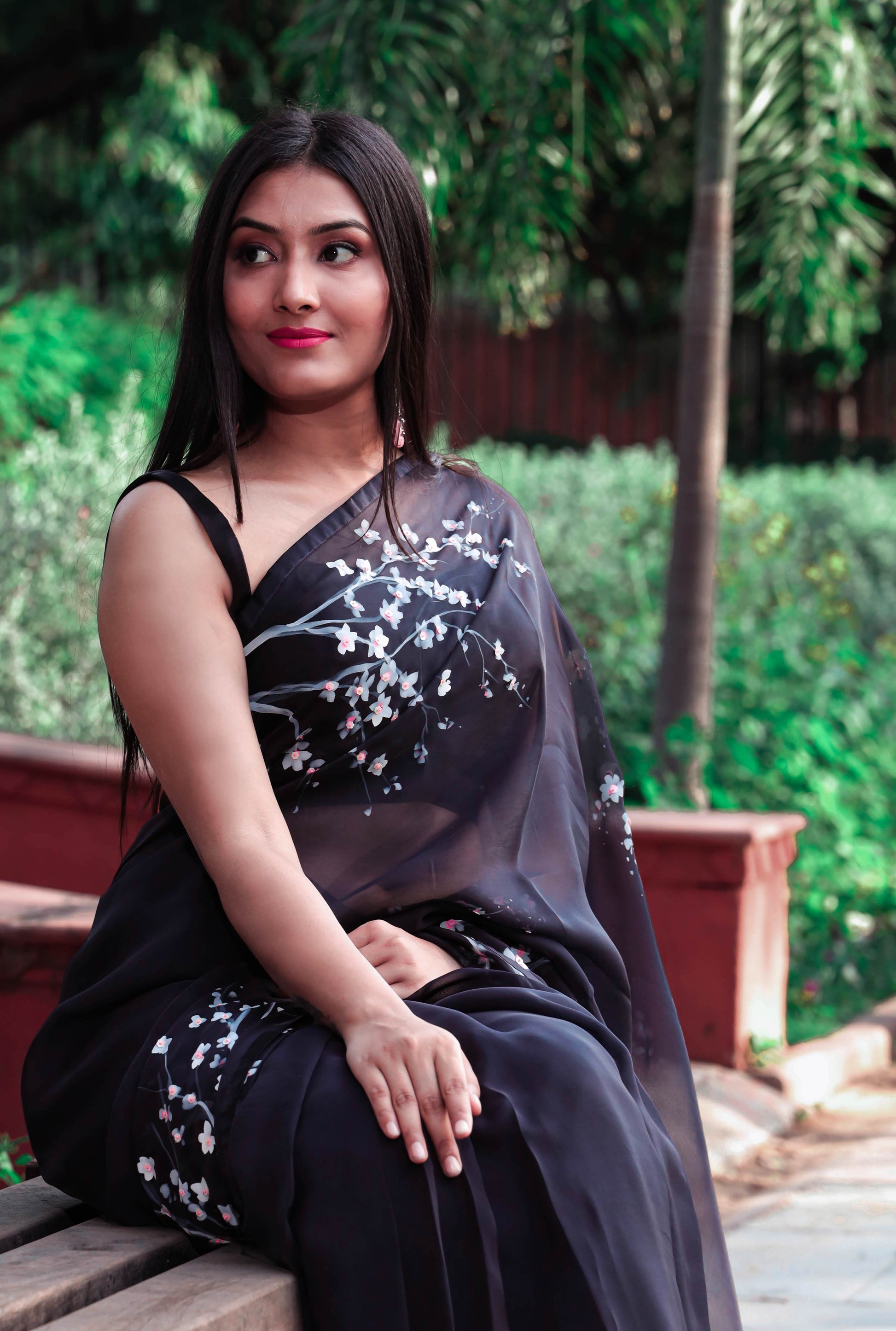 Elegant black organza saree with hand-painted floral design, perfect for parties and special occasions. Features a stunning black saree blouse design and intricate hand painting on saree. This organza saree offers a chic and stylish look, ideal for women who appreciate black saree in silk. A fashionable choice for black saree party wear