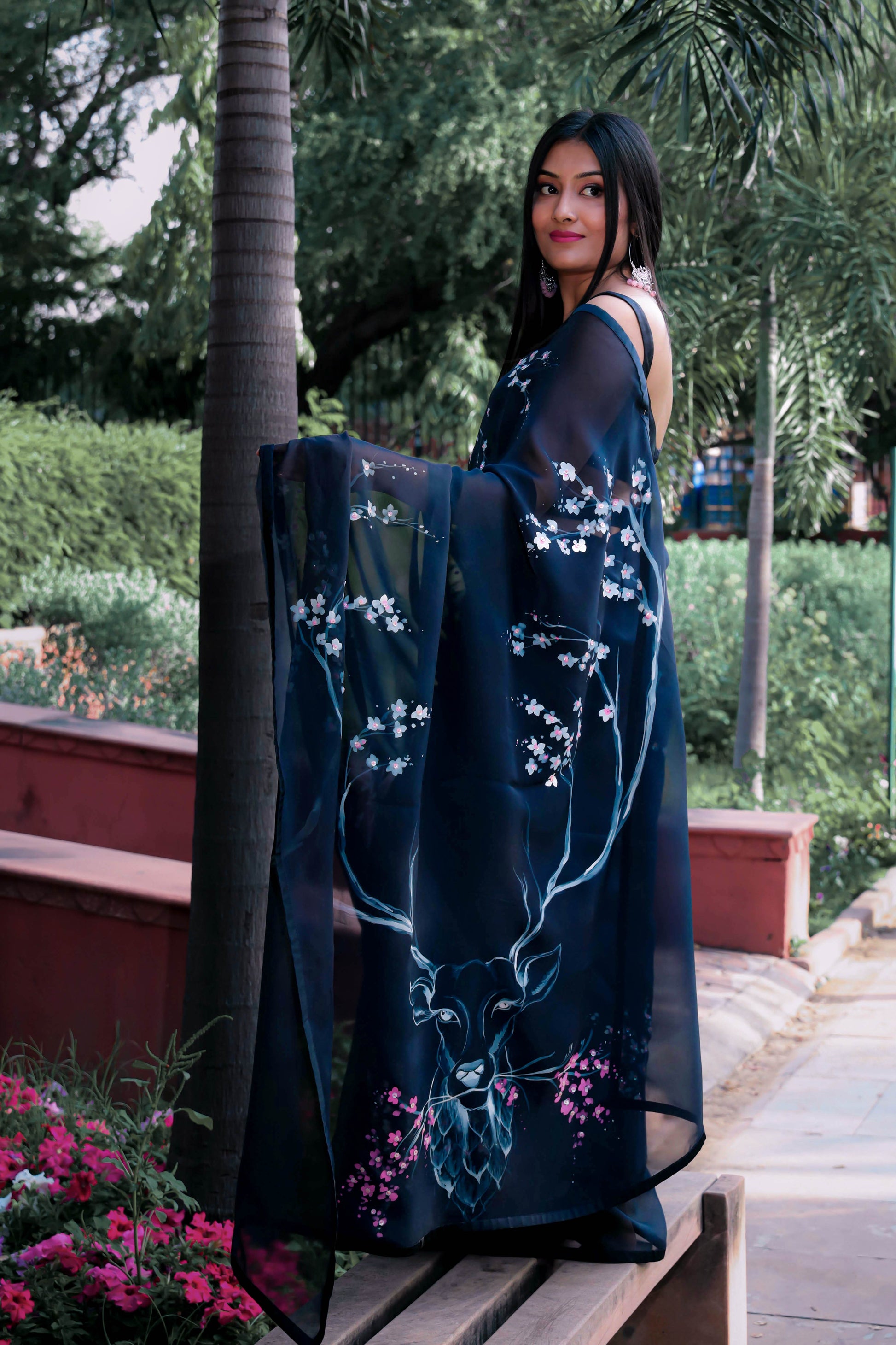 Elegant black organza saree with hand-painted floral design, perfect for parties and special occasions. Features a stunning black saree blouse design and intricate hand painting on saree. This organza saree offers a chic and stylish look, ideal for women who appreciate black saree in silk. A fashionable choice for black saree party wear