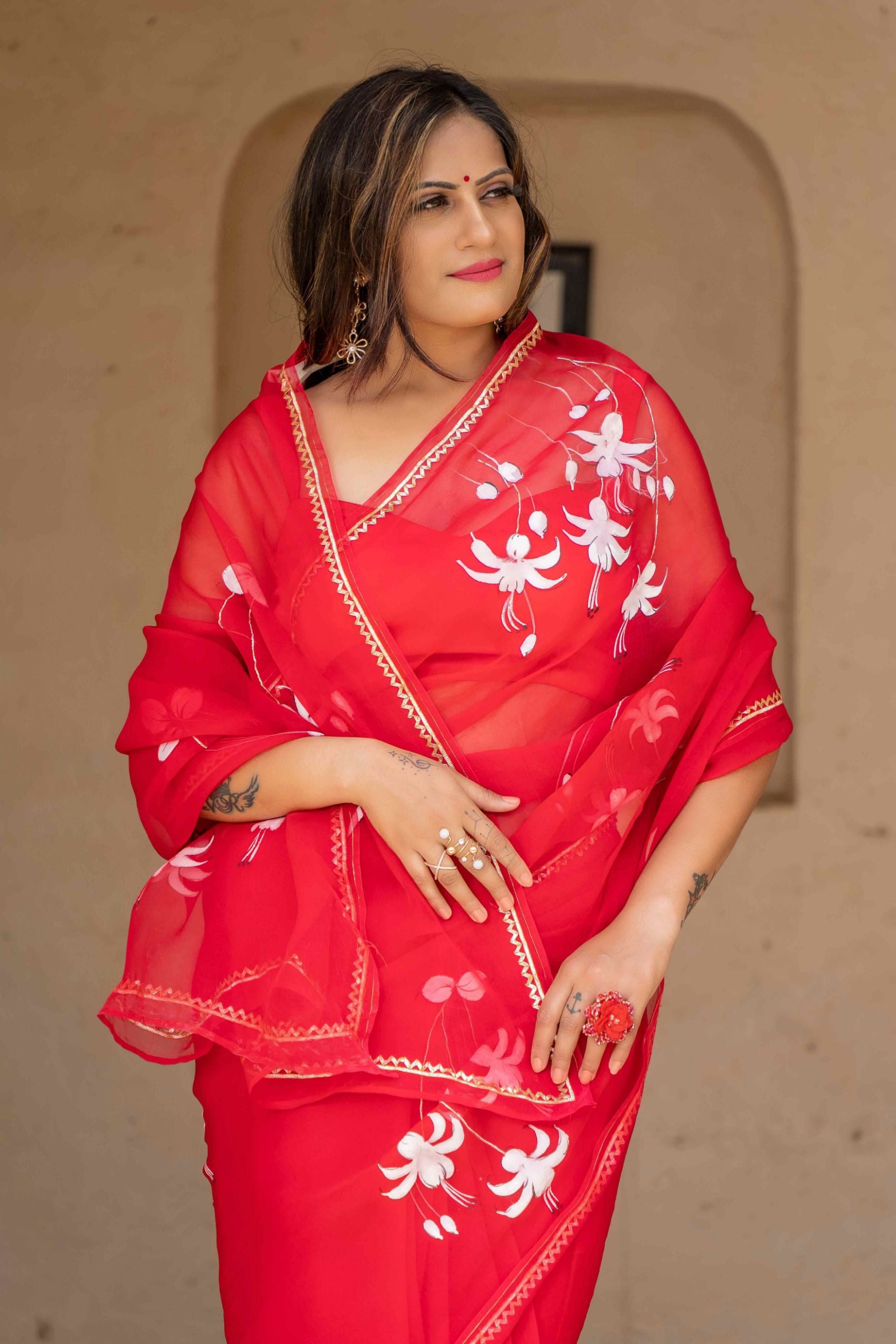 Hand-Painted Red Pure Silk Organza Saree with White Fuchsia Flowers and Metal Gota Embroidery - Perfect for Indian Weddings and Parties. Shop this Stunning Organza Saree Online for a Hot Saree Style. This Pure Silk Saree Features Exquisite Cloth Painting and Textile Paint for Fabric, Making it a Unique Hand-Painted Saree. Get the Saree Look You Desire with this Simple Saree Design. Explore Our Saree Shop for More Sadi Ka Design and Saree Options.