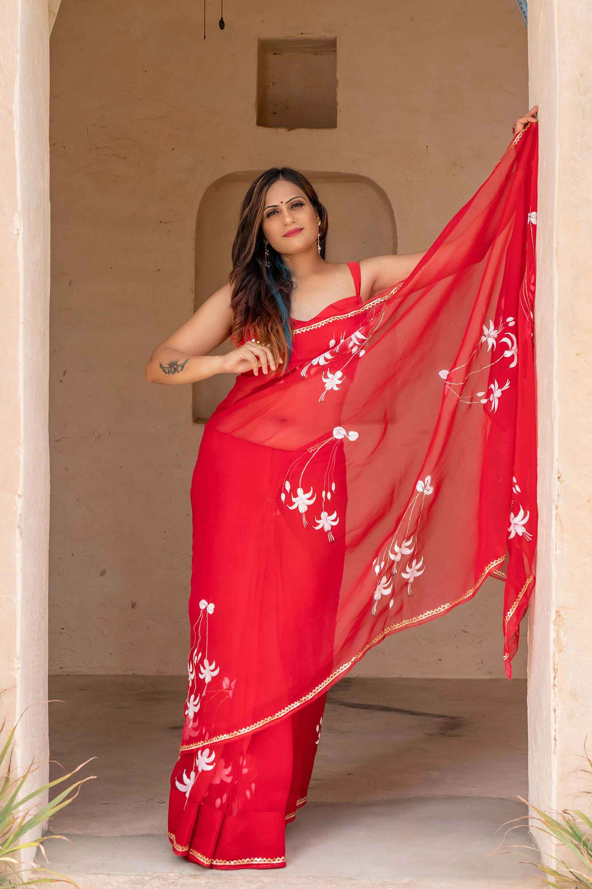 Hand-Painted Red Pure Silk Organza Saree with White Fuchsia Flowers and Metal Gota Embroidery - Perfect for Indian Weddings and Parties. Shop this Stunning Organza Saree Online for a Hot Saree Style. This Pure Silk Saree Features Exquisite Cloth Painting and Textile Paint for Fabric, Making it a Unique Hand-Painted Saree. Get the Saree Look You Desire with this Simple Saree Design. Explore Our Saree Shop for More Sadi Ka Design and Saree Options.