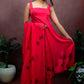 Girl wearing a red colour sleeveless anarkali suit enhanced with hand painted black poppy flowers adorned with delicate bead work., paired with organza handpainted dupatta and a flared palazzo.