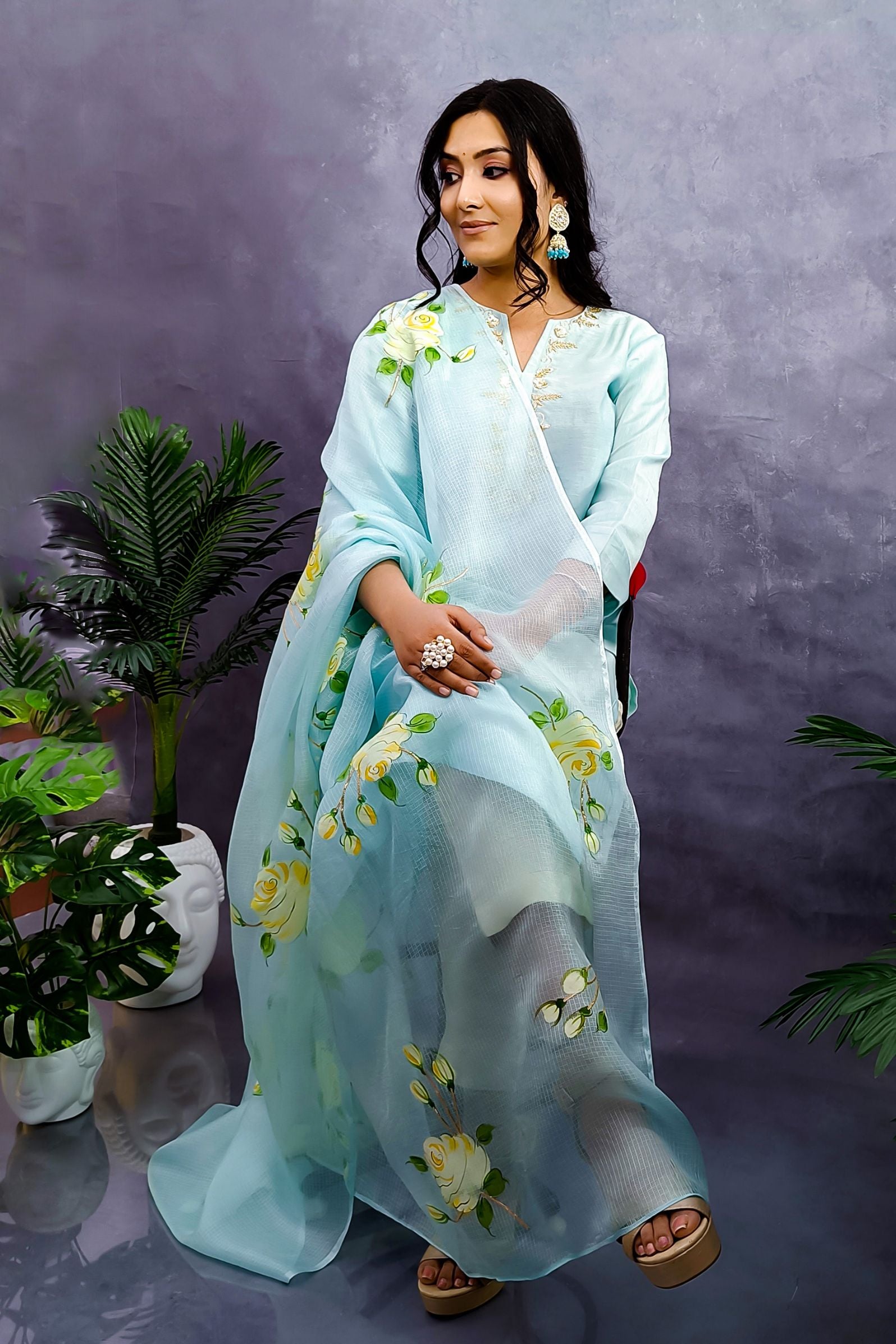 A girl is wearing light turquoise chanderi straight suit  enhanced with zardozi embroidery, paired with pure kota silk dupatta hand painted white roses enhanced with gota embroidery.