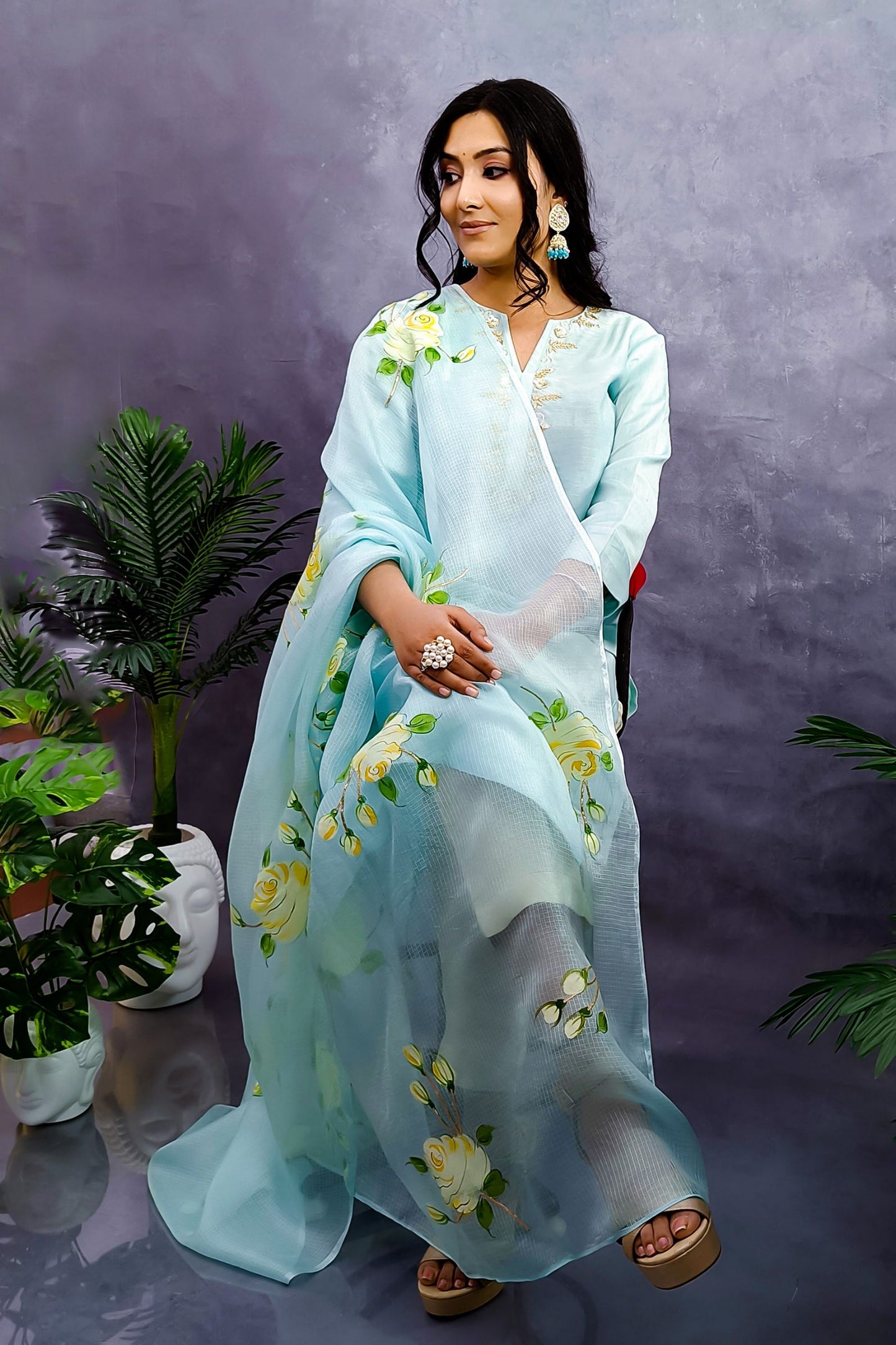 A girl is wearing light turquoise chanderi straight suit  enhanced with zardozi embroidery, paired with pure kota silk dupatta hand painted white roses enhanced with gota embroidery. 