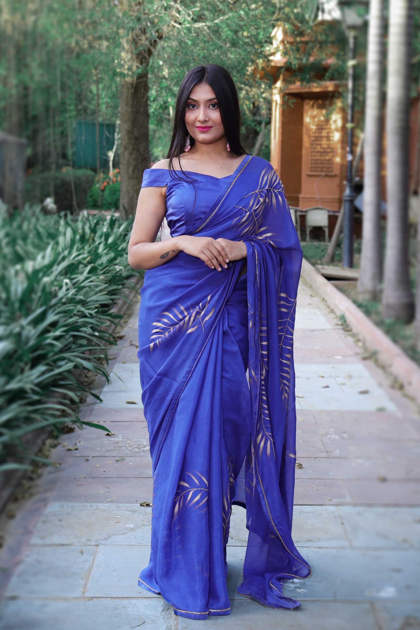 Elegant royal blue chinon chiffon silk saree with hand-painted golden palm leaves and cut beads embroidery. A stunning saree for a stylish, simple saree look. Perfect for weddings and special occasions