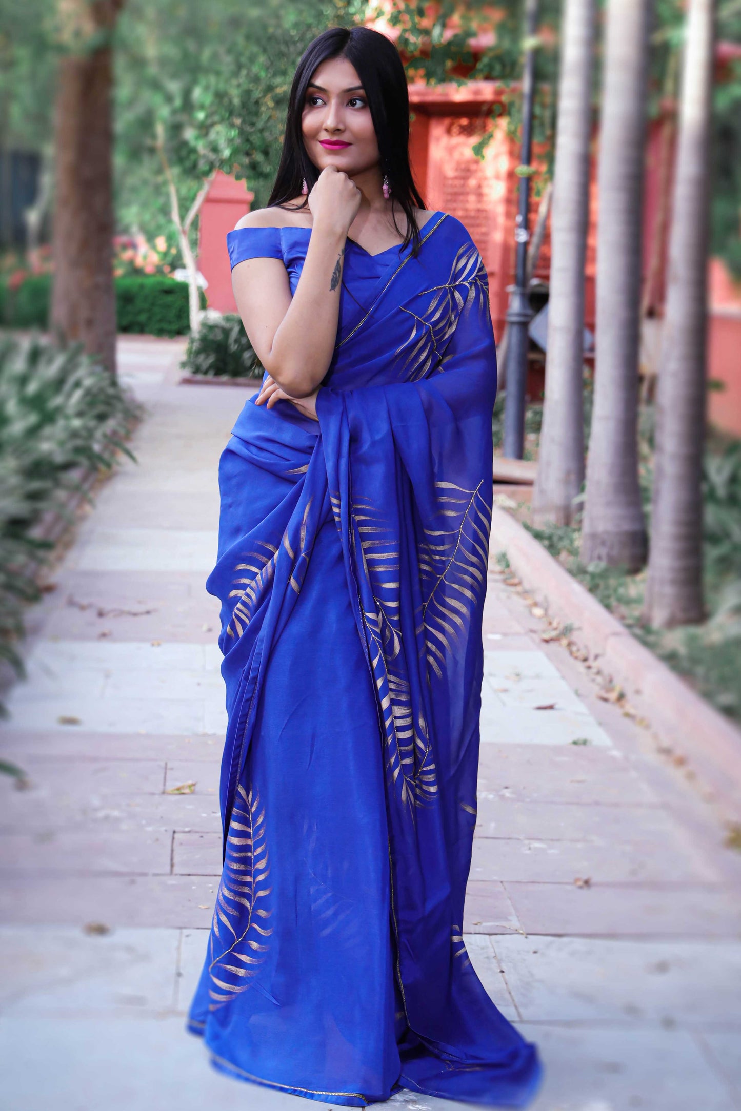 Elegant royal blue chinon chiffon silk saree with hand-painted golden palm leaves and cut beads embroidery. A stunning saree for a stylish, simple saree look. Perfect for weddings and special occasions