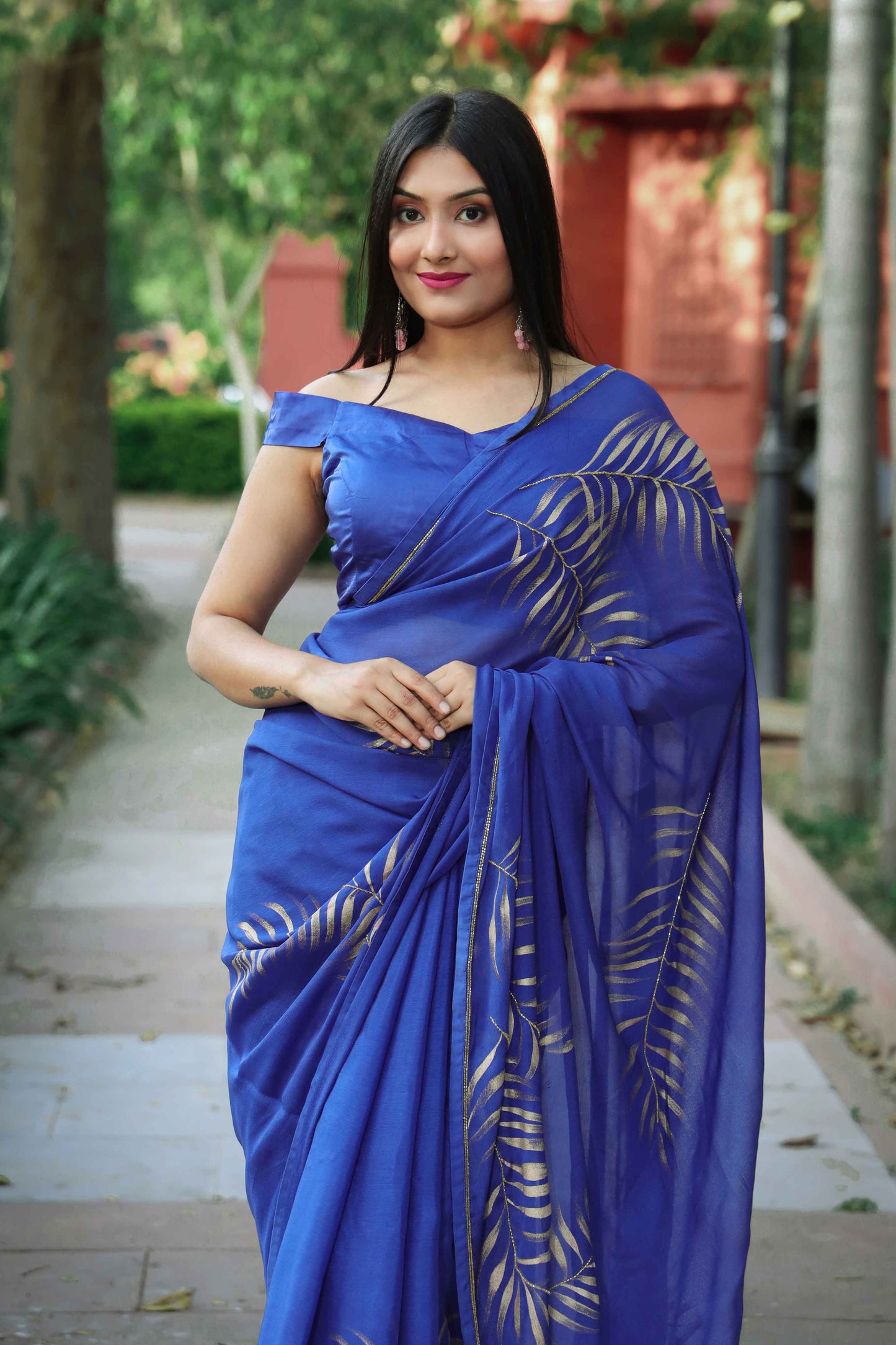 Elegant royal blue chinon chiffon silk saree with hand-painted golden palm leaves and cut beads embroidery. A stunning saree for a stylish, simple saree look. Perfect for weddings and special occasions