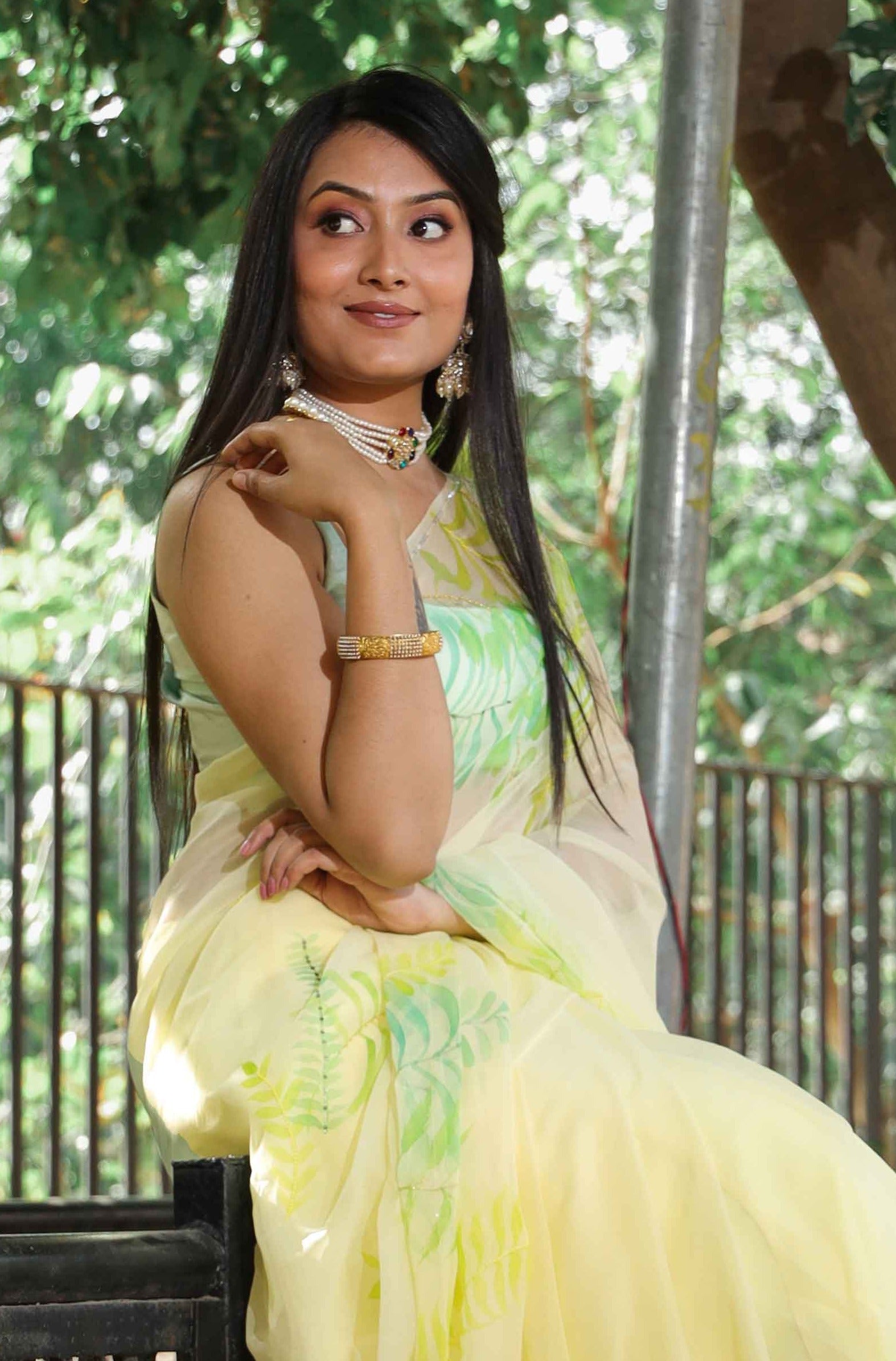 Elegant royal blue chiffon saree adorned with hand-painted green fern leaves and enhanced with glass beads and sequin embroidery. A chic and stylish chiffon saree with a transparent look