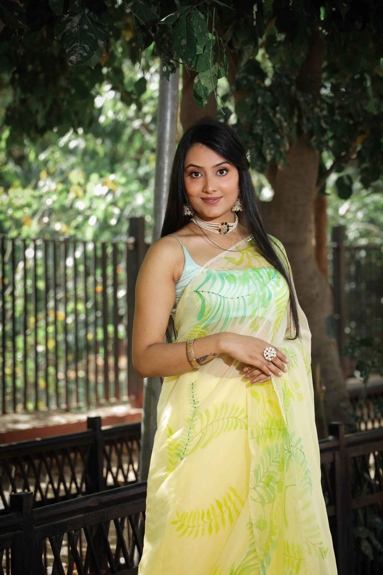 Elegant royal blue chiffon saree adorned with hand-painted green fern leaves and enhanced with glass beads and sequin embroidery. A chic and stylish chiffon saree with a transparent look