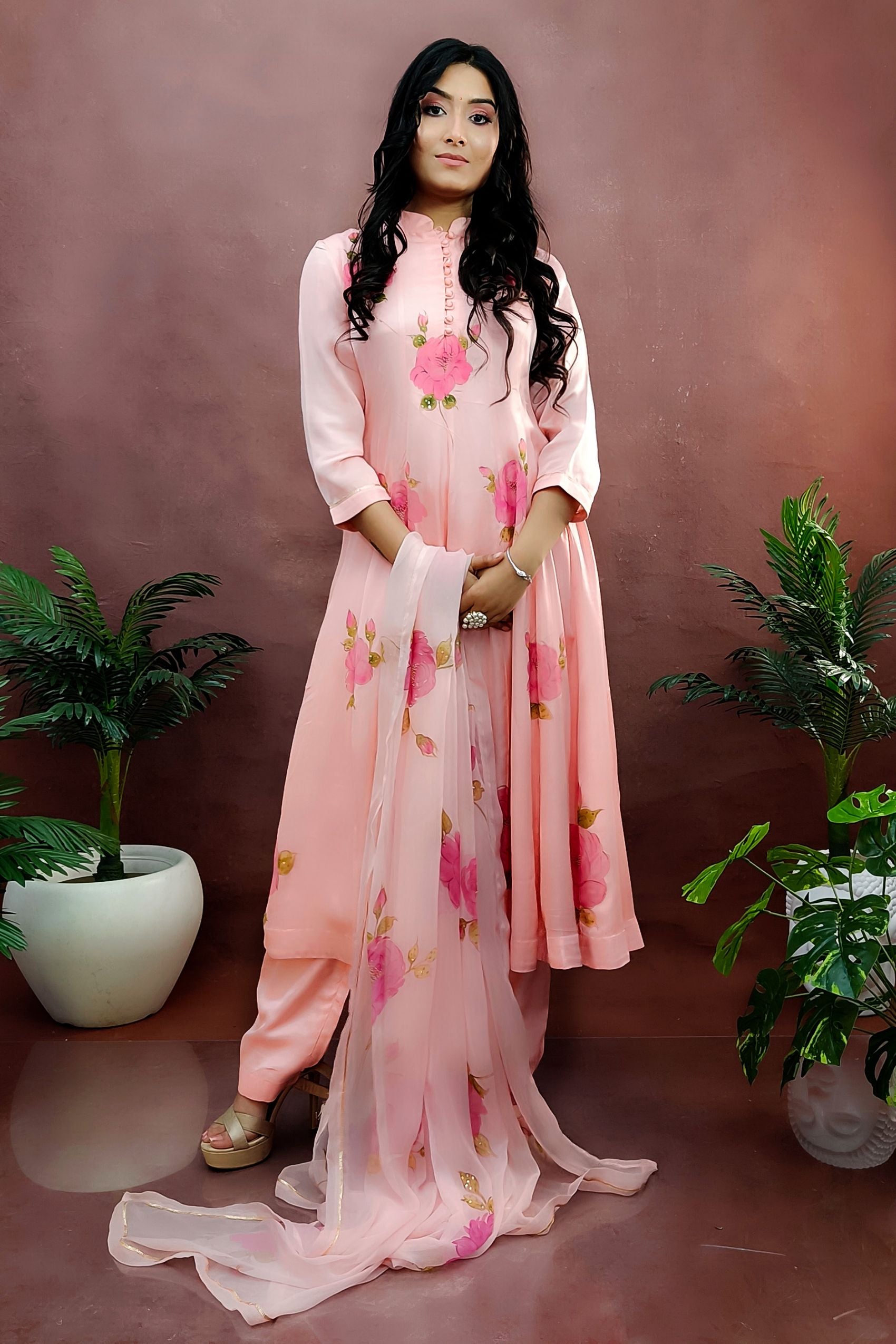 Peach color hand painted anarkali suit with bright pink roses enhanced with beads and sequin embroidery.
