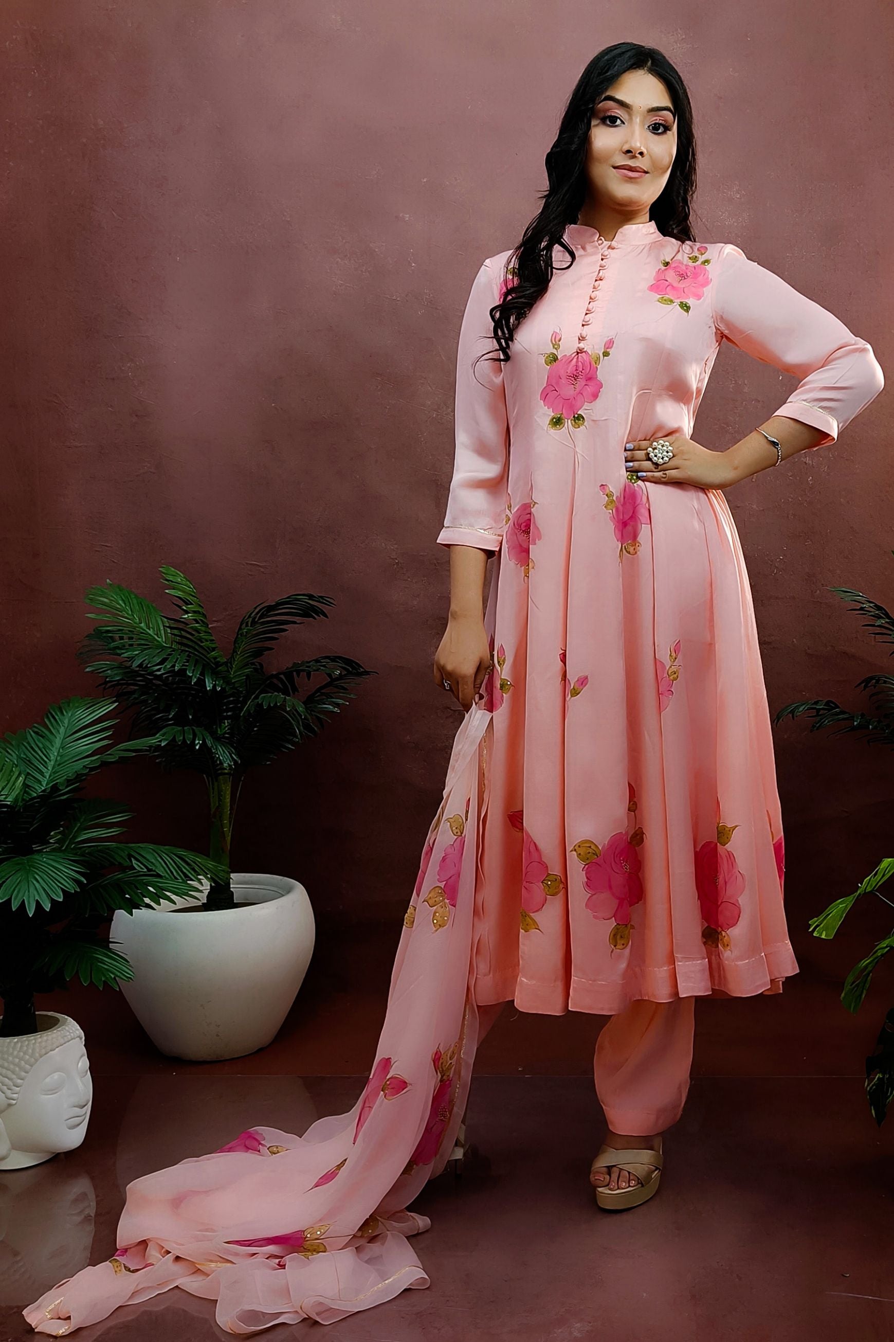 Peach color hand painted anarkali suit with bright pink roses enhanced with beads and sequin embroidery.