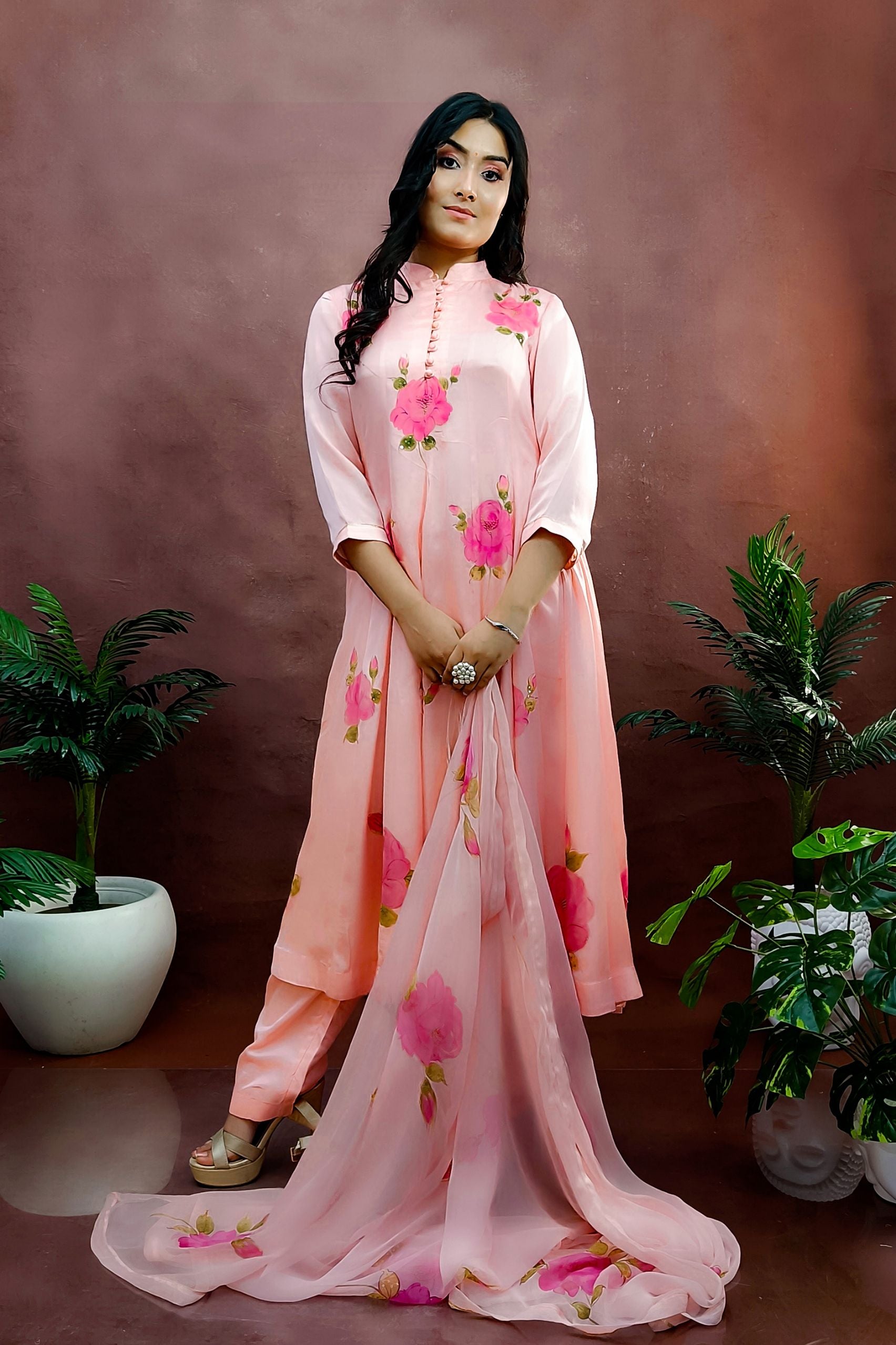 Peach color hand painted anarkali suit with bright pink roses enhanced with beads and sequin embroidery.