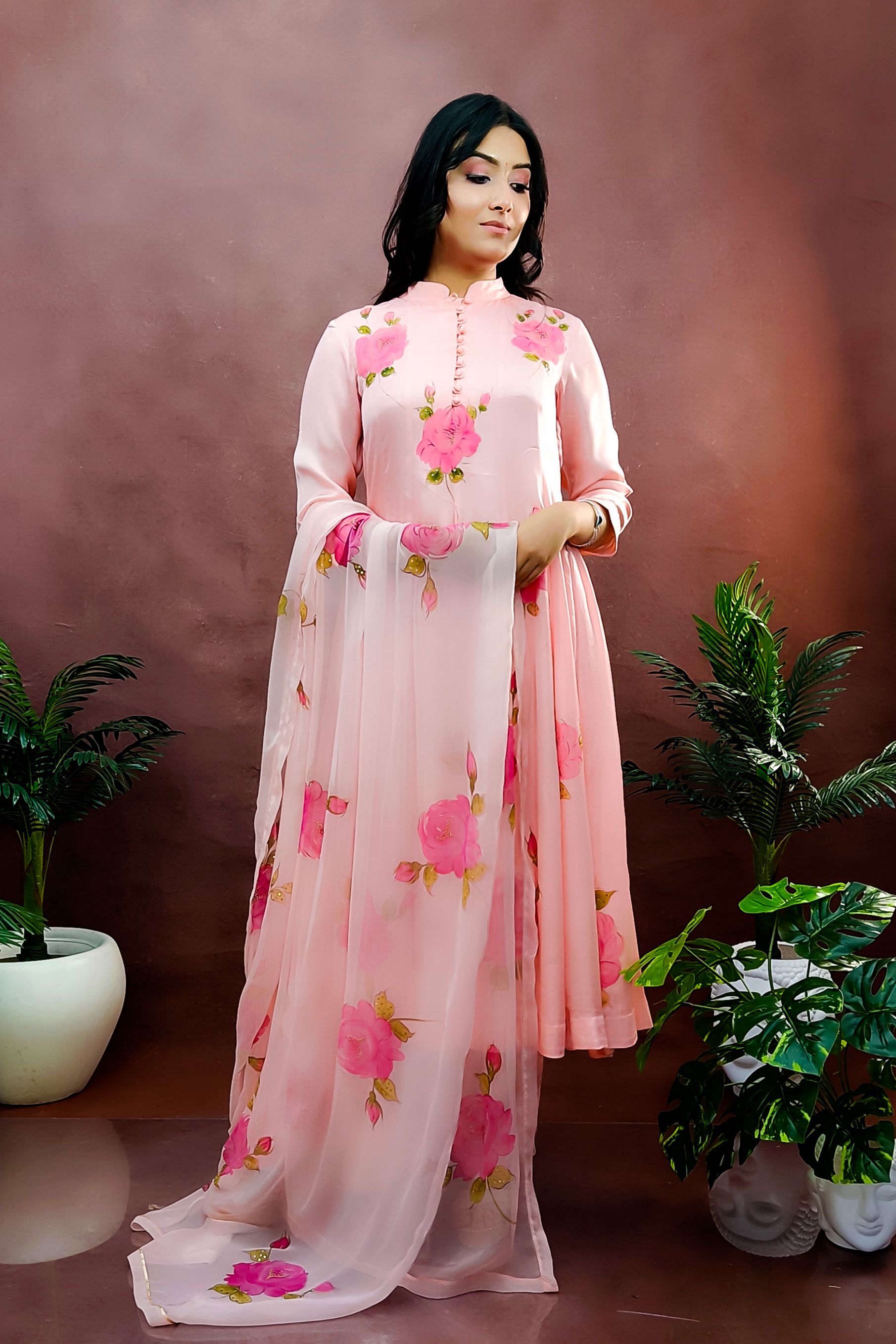 Peach color hand painted anarkali suit with bright pink roses enhanced with beads and sequin embroidery.