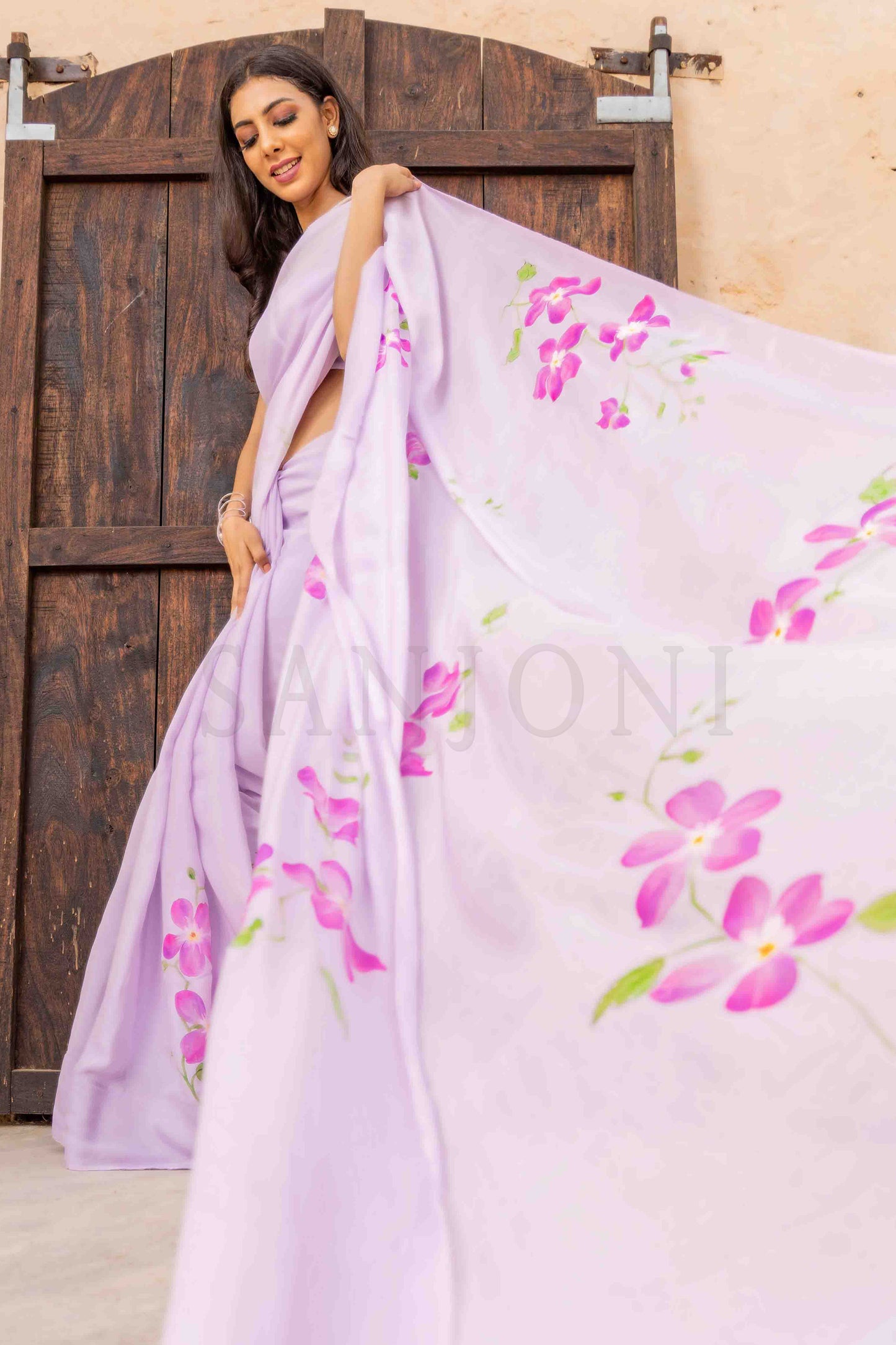 best price hand painted chinon chiffon saree with orchid flowers painted allover enhanced with beads and sequin work. 