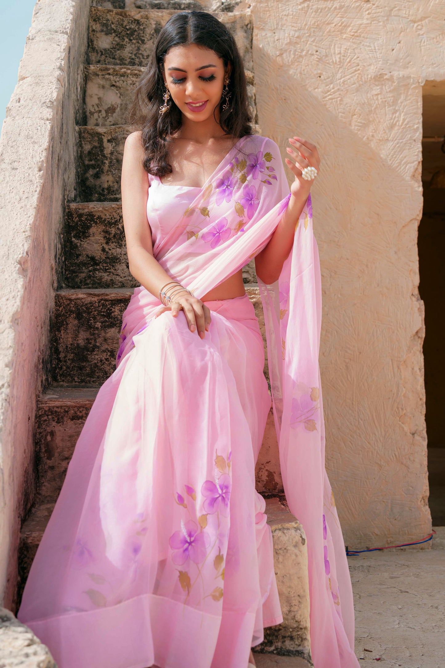 hand painted hibiscus flowers on soft pink chiffon saree enhanced with sequin and pearl embroidery.