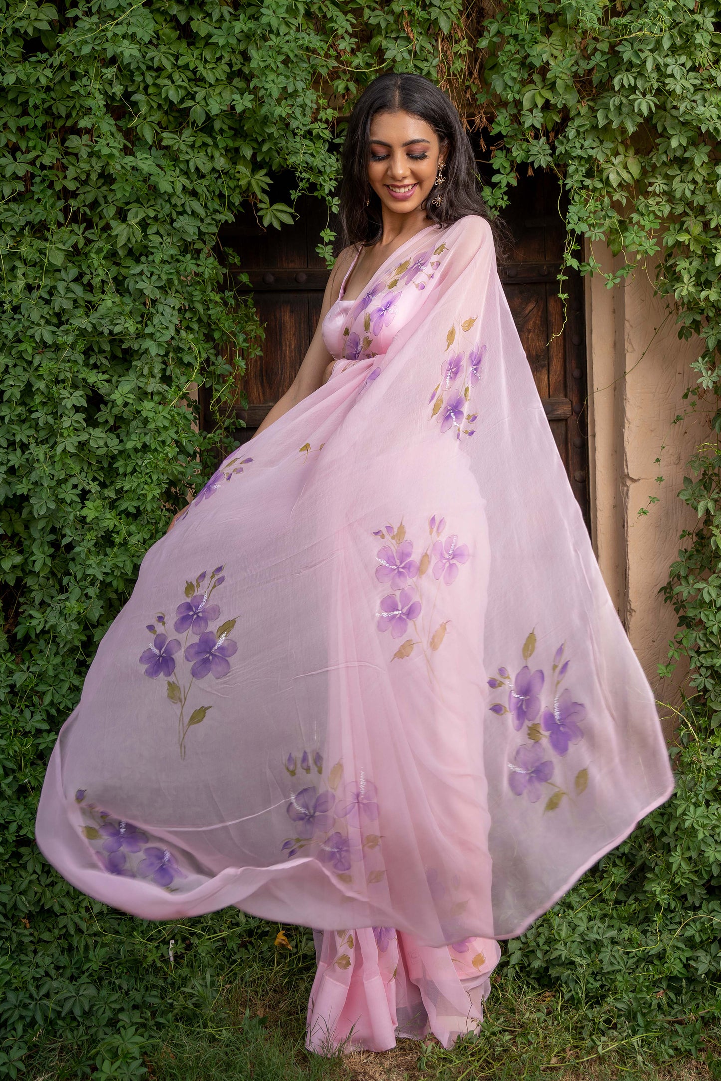 hand painted hibiscus flowers on soft pink chiffon saree enhanced with sequin and pearl embroidery.