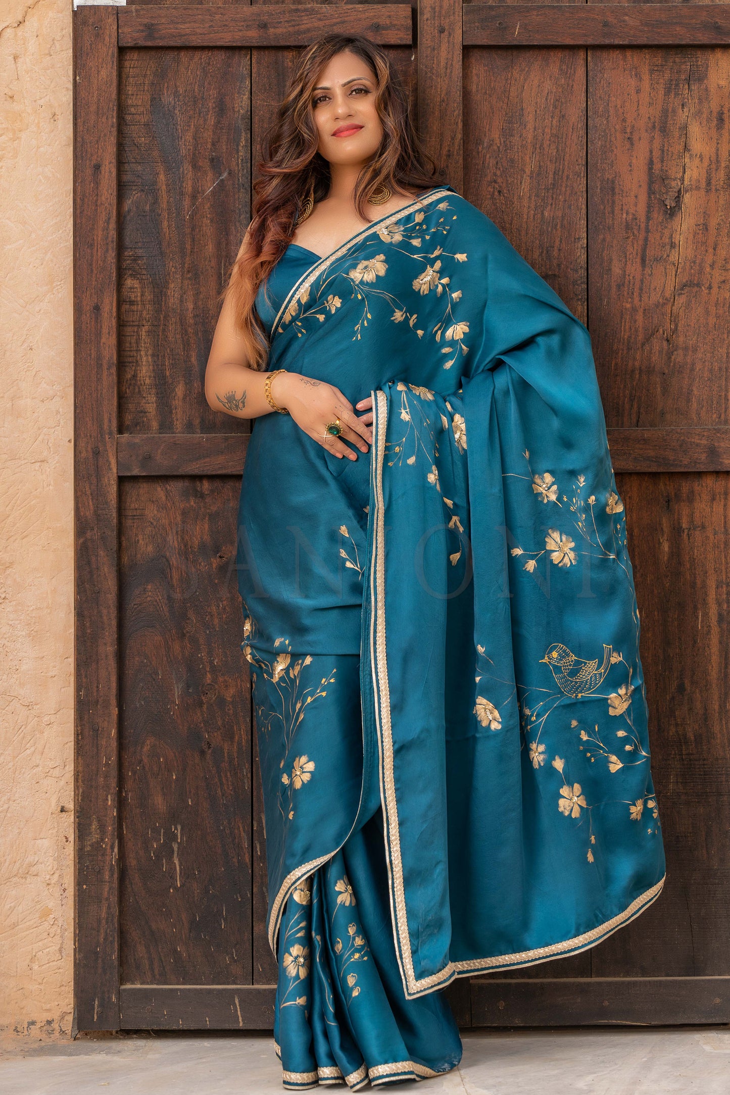 see green satin hand painted saree with golden flowers enhanced with sequin and bead work.