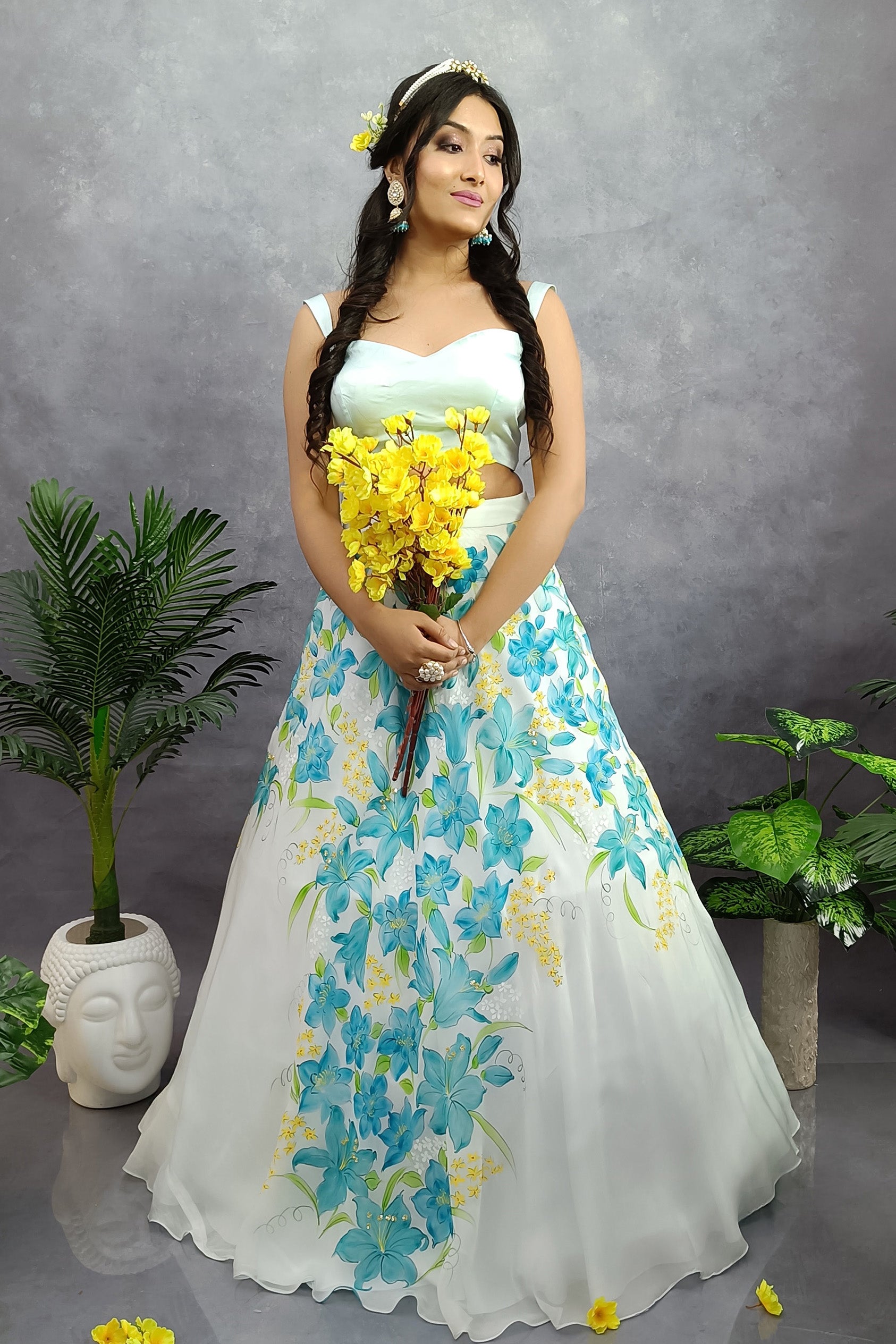 Girl is wearing Hand painted turquoise hand painted lehenga enhanced with sequin and gota embroidery, paired with organza dupatta .