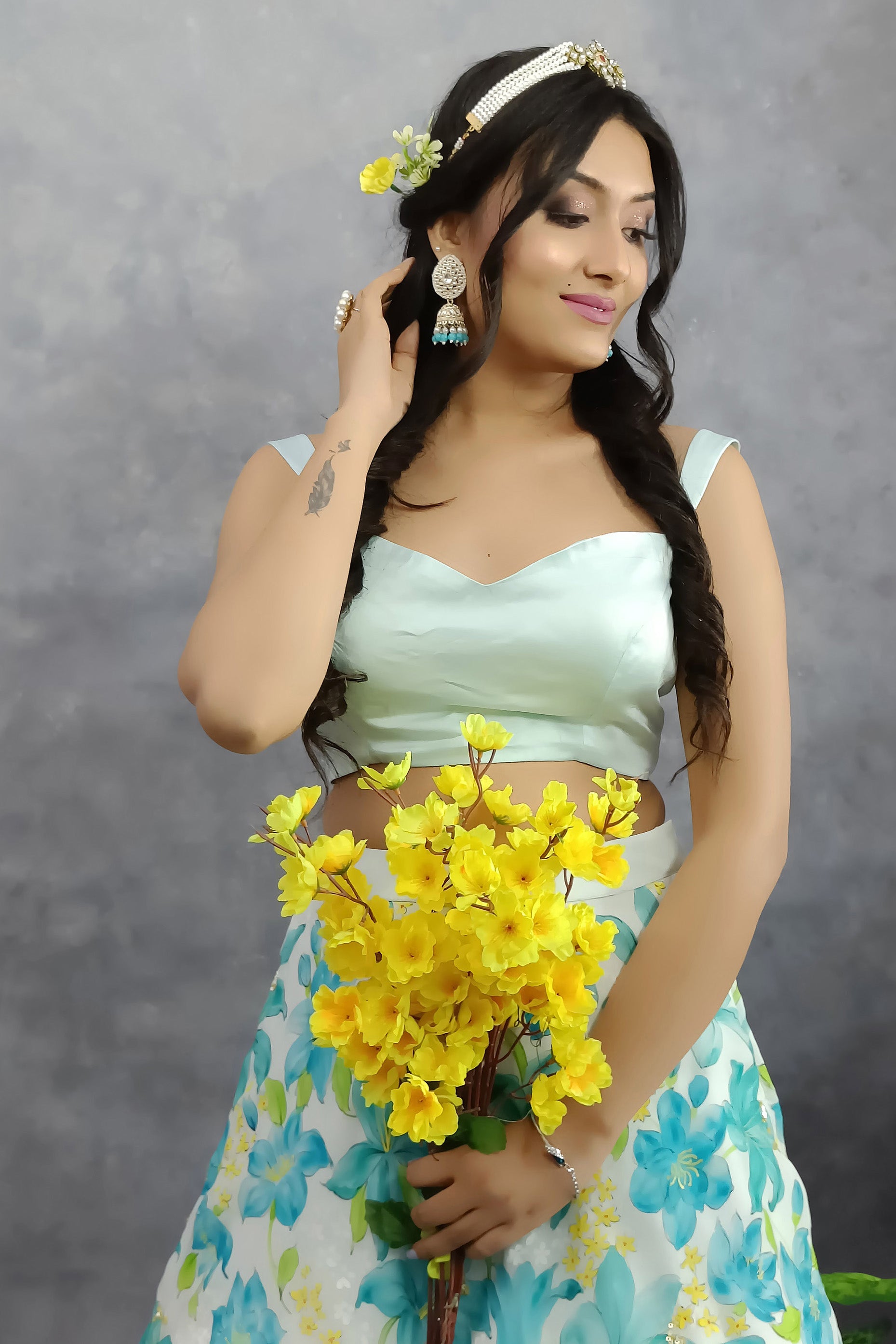 Girl is wearing Hand painted turquoise hand painted lehenga enhanced with sequin and gota embroidery, paired with organza dupatta .