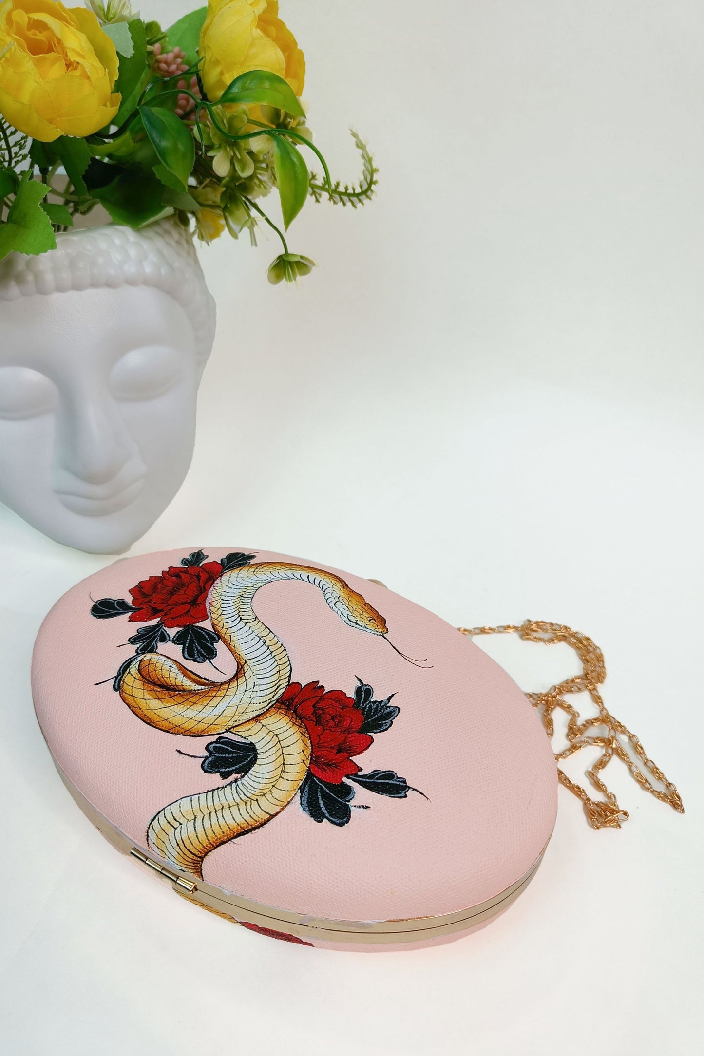 Hand-Painted Clutch with Python sitting on Red Rose Flowers Design - Customized Canvas Bag with Sling. Unique Hand-Painted Purse for Evening Events. Explore our Hand-Painted Handbags and Customized Ladies Purse with Name Options. Perfect Bag Design Online. Ideal for a Personalized and Stylish Look. Get Your Painted Designer Bag Today