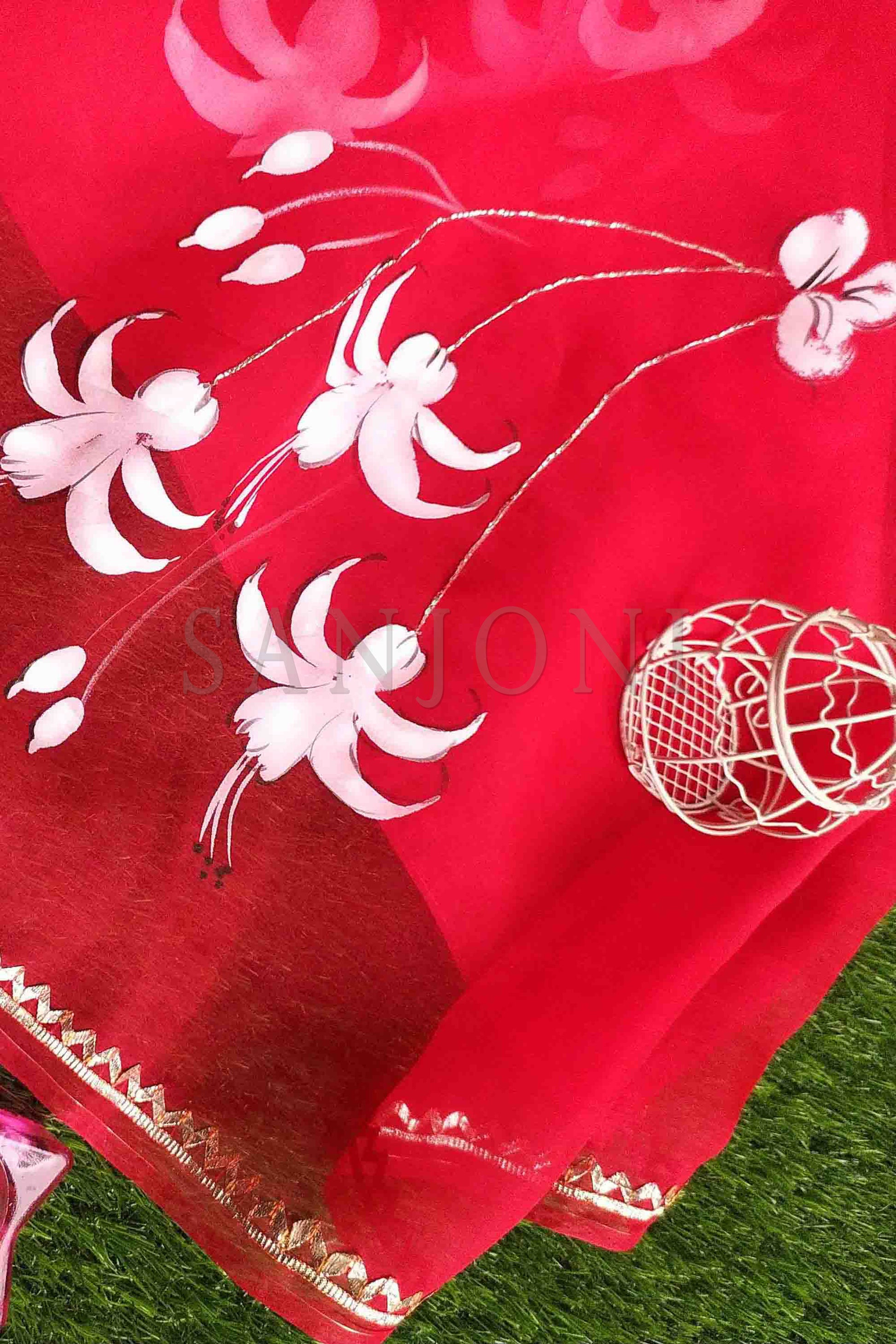 Hand-Painted Red Pure Silk Organza Saree with White Fuchsia Flowers and Metal Gota Embroidery - Perfect for Indian Weddings and Parties. Shop this Stunning Organza Saree Online for a Hot Saree Style. This Pure Silk Saree Features Exquisite Cloth Painting and Textile Paint for Fabric, Making it a Unique Hand-Painted Saree. Get the Saree Look You Desire with this Simple Saree Design. Explore Our Saree Shop for More Sadi Ka Design and Saree Options.