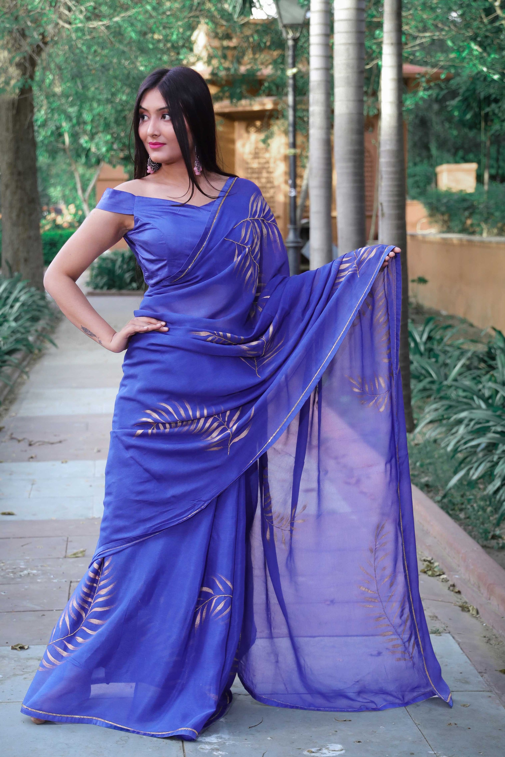 Elegant royal blue chinon chiffon silk saree with hand-painted golden palm leaves and cut beads embroidery. A stunning saree for a stylish, simple saree look. Perfect for weddings and special occasions