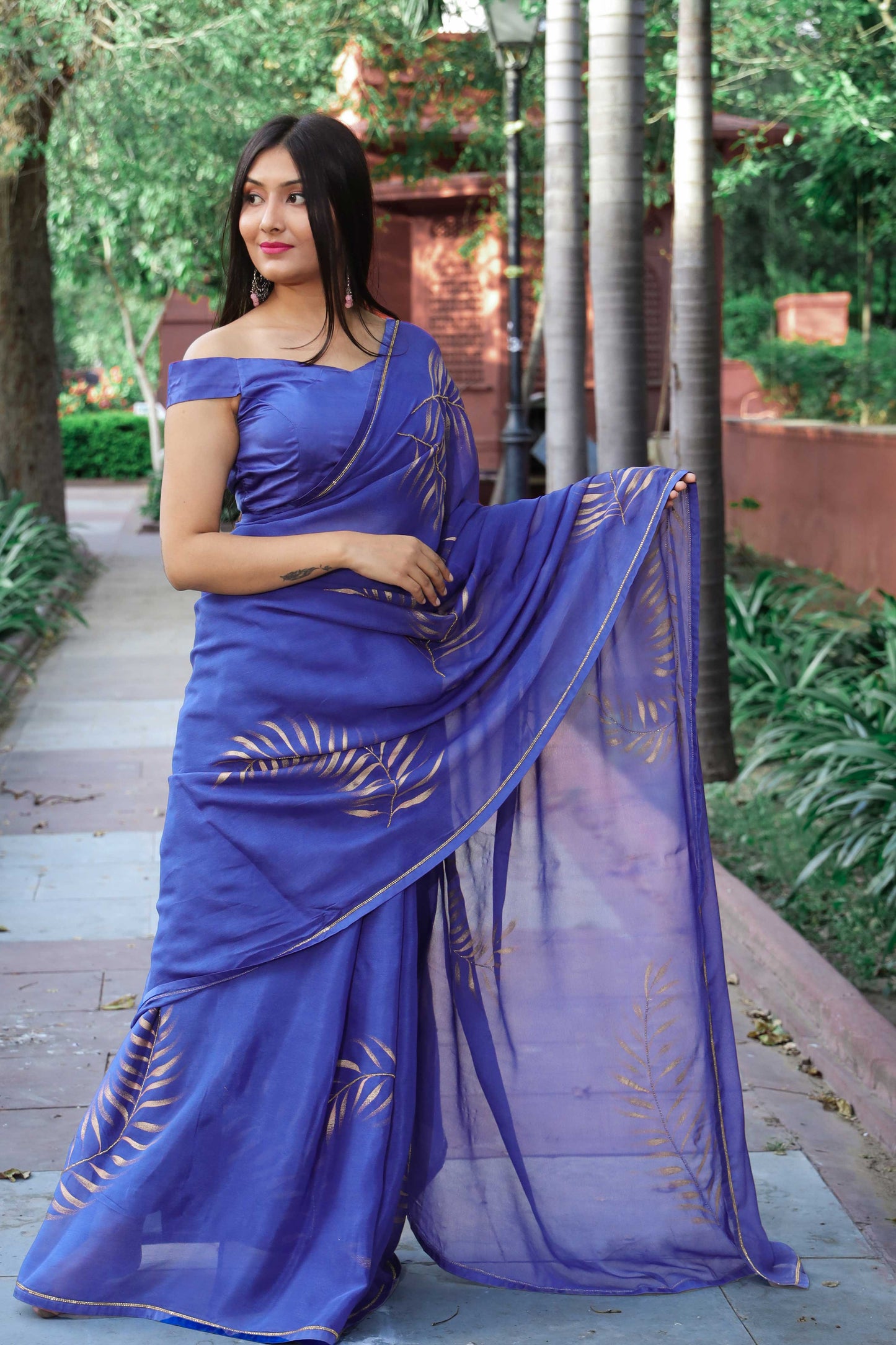 Elegant royal blue chinon chiffon silk saree with hand-painted golden palm leaves and cut beads embroidery. A stunning saree for a stylish, simple saree look. Perfect for weddings and special occasions