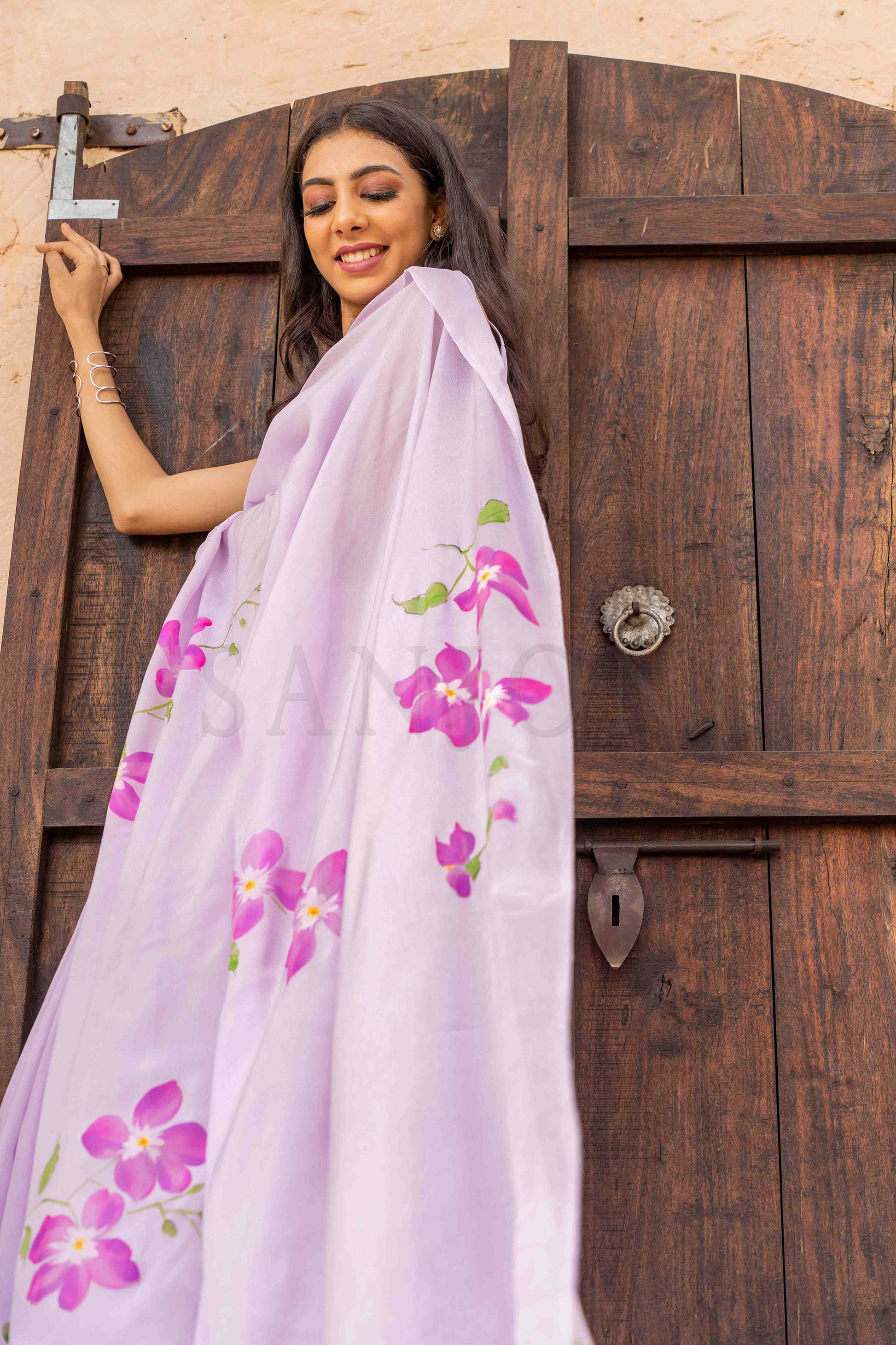 best price hand painted chinon chiffon saree with orchid flowers painted allover enhanced with beads and sequin work. 