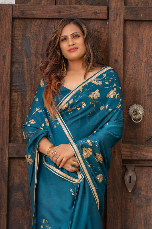 Hand-painted saee green satin saree with golden flowers, enhanced with sequin and bead embroidery.