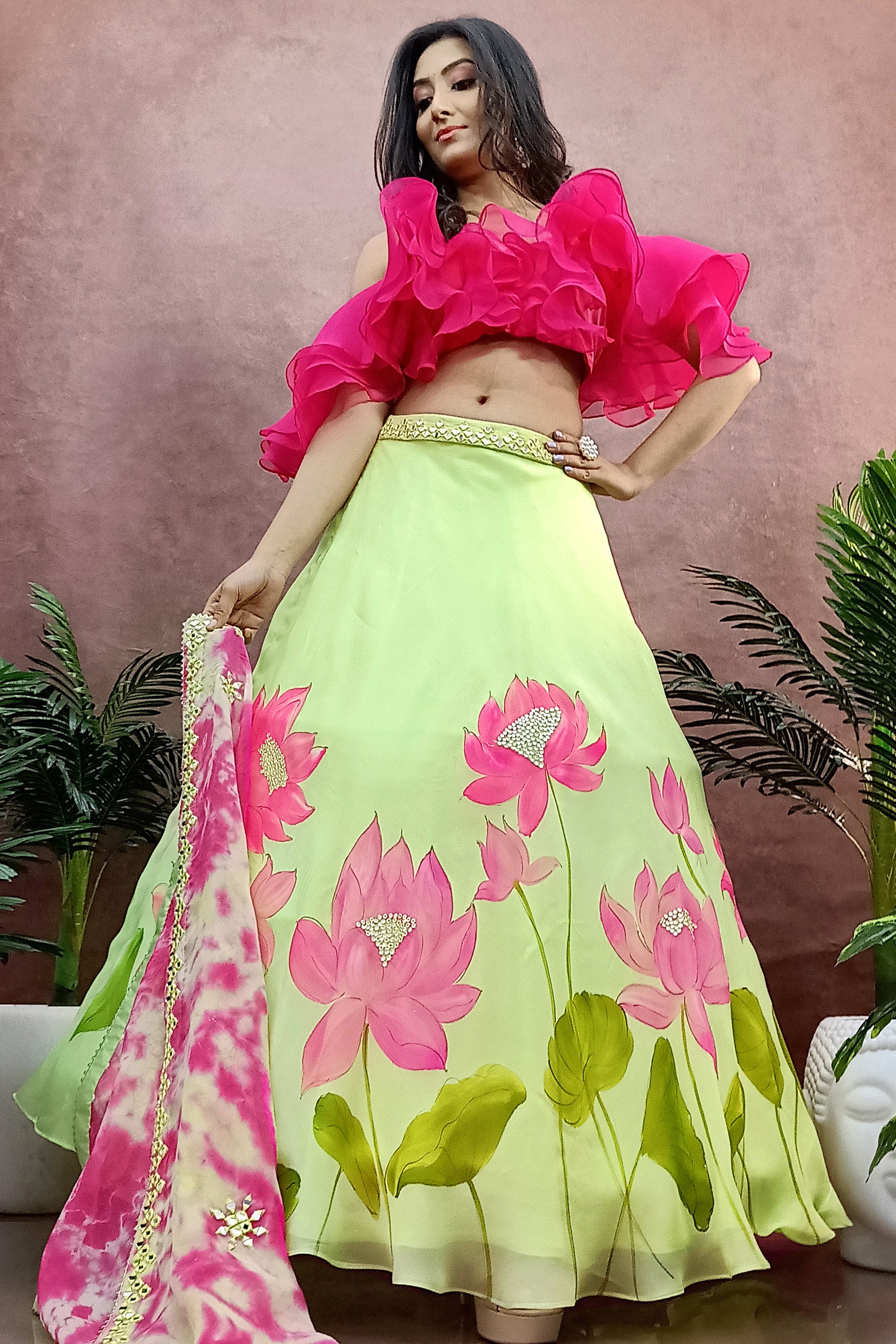 Hand painted lotus lehenga on green organza  paired with tie and die dupatta enhanced with mirror embroidery and a ruffel blouse.